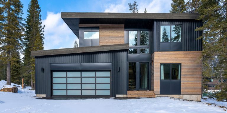 Modern two-storey prefab house with timber and dark steel cladding